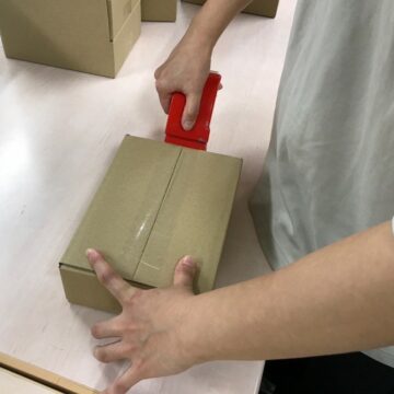 OPPテープでダンボールを止める様子