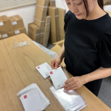 ポストカードをOPP袋に封入する様子